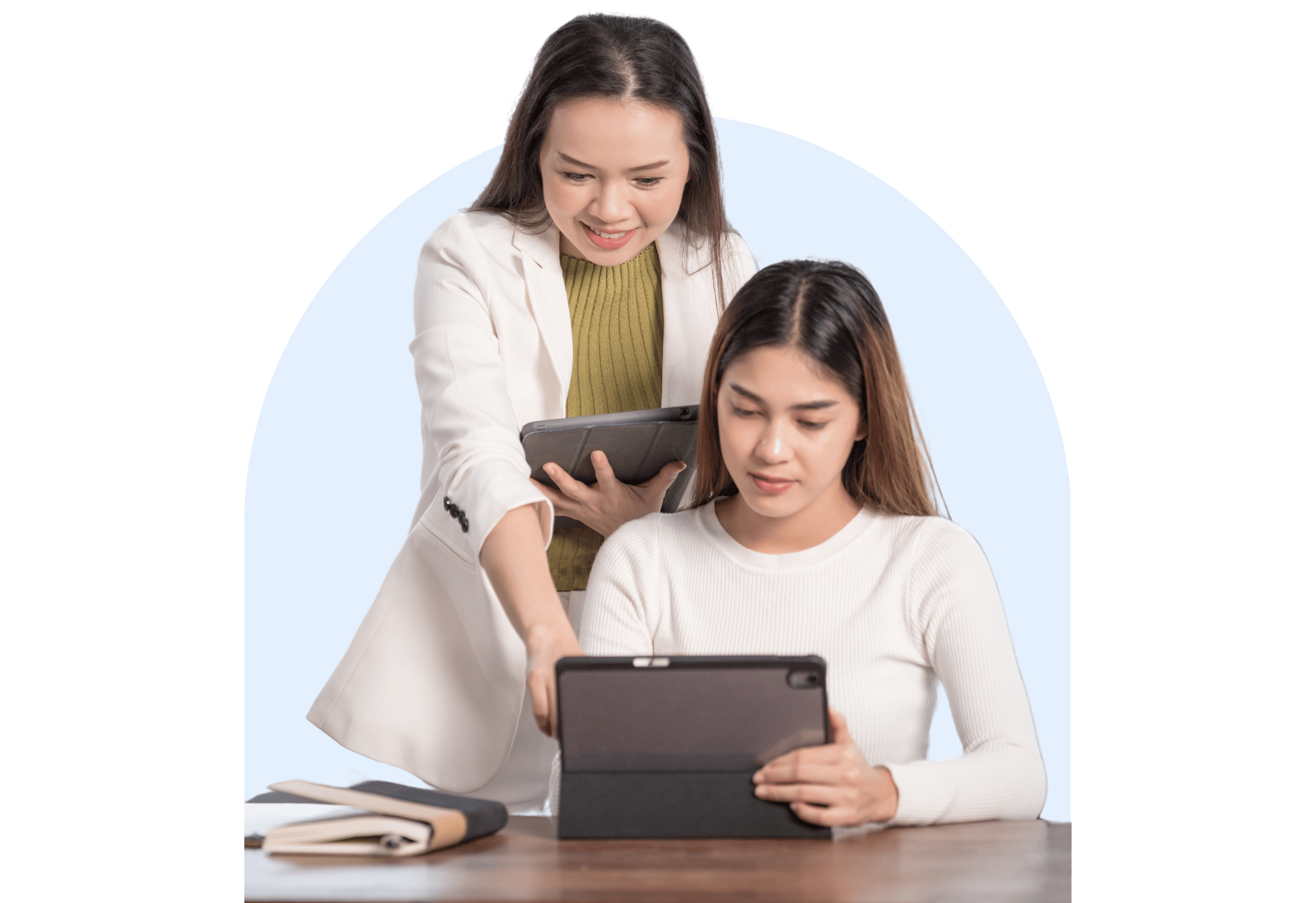 Teacher assisting a student with a tablet in a classroom or study space